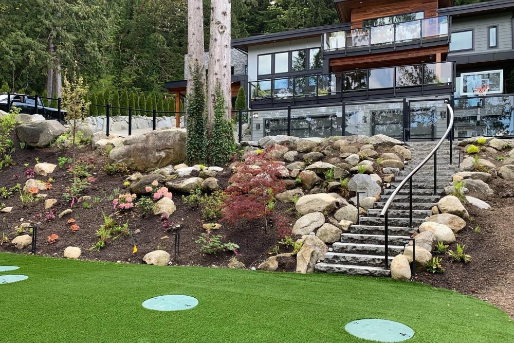Hardscaping with stairway and plants in front of large residential home