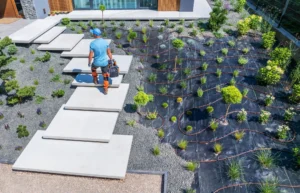 stone patio and pathway integrated with existing lawn garden beds and mature trees in landscaped yard