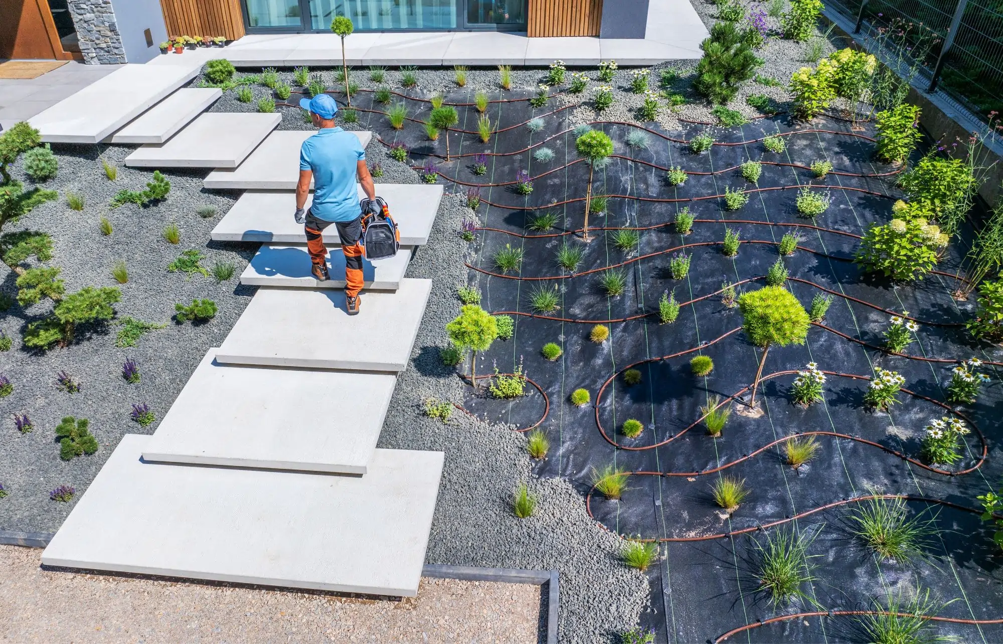 stone patio and pathway integrated with existing lawn garden beds and mature trees in landscaped yard